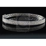A modern 18k white gold and three row diamond set hinged bracelet, inner measurement approximately