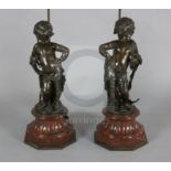 A pair of Victorian bronze figures of putti, with the accoutrements of an archer and a fisherman, on