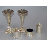 A pair of silver trumpet vases (weighted) and a three-piece silver condiment set.