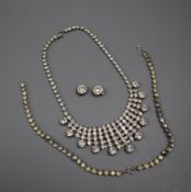 A white metal and paste set fringe necklace, two paste bracelets and a pair of earrings.