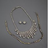 A white metal and paste set fringe necklace, two paste bracelets and a pair of earrings.