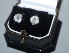 A modern pair of 18ct white gold and solitaire round brilliant cut diamond ear studs, each stone