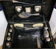 An Edwardian crocodile skin travelling toilet case, containing approximately twenty eight silver