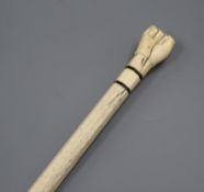 A 19th century scrimshaw whalebone and marine ivory walking stick, the handle carved as a clenched