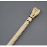 A 19th century scrimshaw whalebone and marine ivory walking stick, the handle carved as a clenched