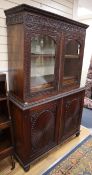 A 19th century Anglo Indian carved Padouk cabinet with glazed upper section W.120cm