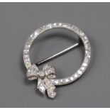 A mid 20th century white metal and diamond set openwork circular brooch with ribbon bow motif,