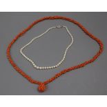 A coral ropetwist necklace with coral cluster drop and a single strand graduated cultured pearl