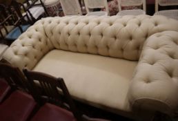 A late Victorian drop arm Chesterfield settee, upholstered in buttoned pale fabric W.180cm