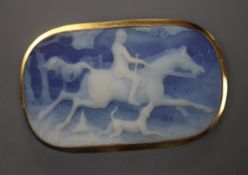 An Italian 750 yellow metal mounted blue jasper oval pendant brooch, carved with a hunting scene,