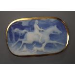 An Italian 750 yellow metal mounted blue jasper oval pendant brooch, carved with a hunting scene,