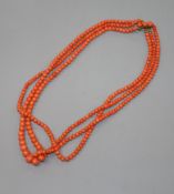 An early-mid 20th century triple strand graduated coral bead necklace, with yellow metal and coral