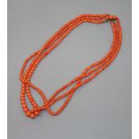 An early-mid 20th century triple strand graduated coral bead necklace, with yellow metal and coral