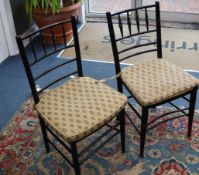 A matched set of eight ebonised Sussex style rush seated dining chairs