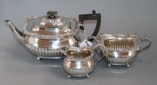 An Edwardian three-piece silver tea service of half-fluted gadrooned form, London 1906, William