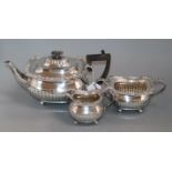 An Edwardian three-piece silver tea service of half-fluted gadrooned form, London 1906, William