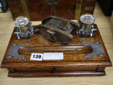 A late Victorian oak inkstand, with later brass trench art tank surmount width 28cm