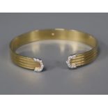 A 9ct. gold and diamond set open bangle.