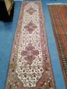 A Caucasian design red and cream ground runner approx. 300 x 80cm