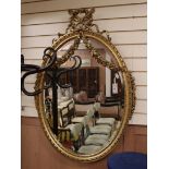 An ornate late 19th century French giltwood oval wall mirror H.115cm