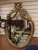 An ornate late 19th century French giltwood oval wall mirror H.115cm