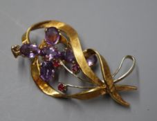 An 18ct white and yellow gold openwork ruby-set ribbon brooch and a 9ct gold and amethyst cross