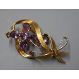 An 18ct white and yellow gold openwork ruby-set ribbon brooch and a 9ct gold and amethyst cross