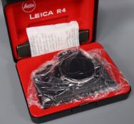 A Leitz black Leica R4 body in presentation box, a Zeiss Ikon Super Ikonta folding bellows camera