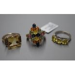 An 750 white metal three-stone ring, a multi gem-set 9ct gold dress ring and a 9ct gold three-