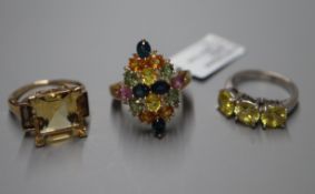 An 750 white metal three-stone ring, a multi gem-set 9ct gold dress ring and a 9ct gold three-