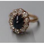 A Finnish 585 yellow metal, cabochon sapphire and diamond set oval cluster ring, size N/O.