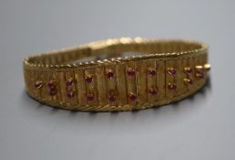 An 18ct gold articulated bracelet composed of graduated batons set with 20 small rubies, 38g approx