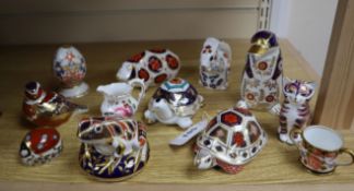 Ten Royal Crown Derby paperweights, a miniature Derby cup and a cream jug
