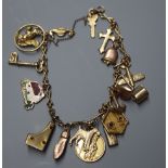 A 9ct charm bracelet, hung with assorted gold and yellow metal charms.