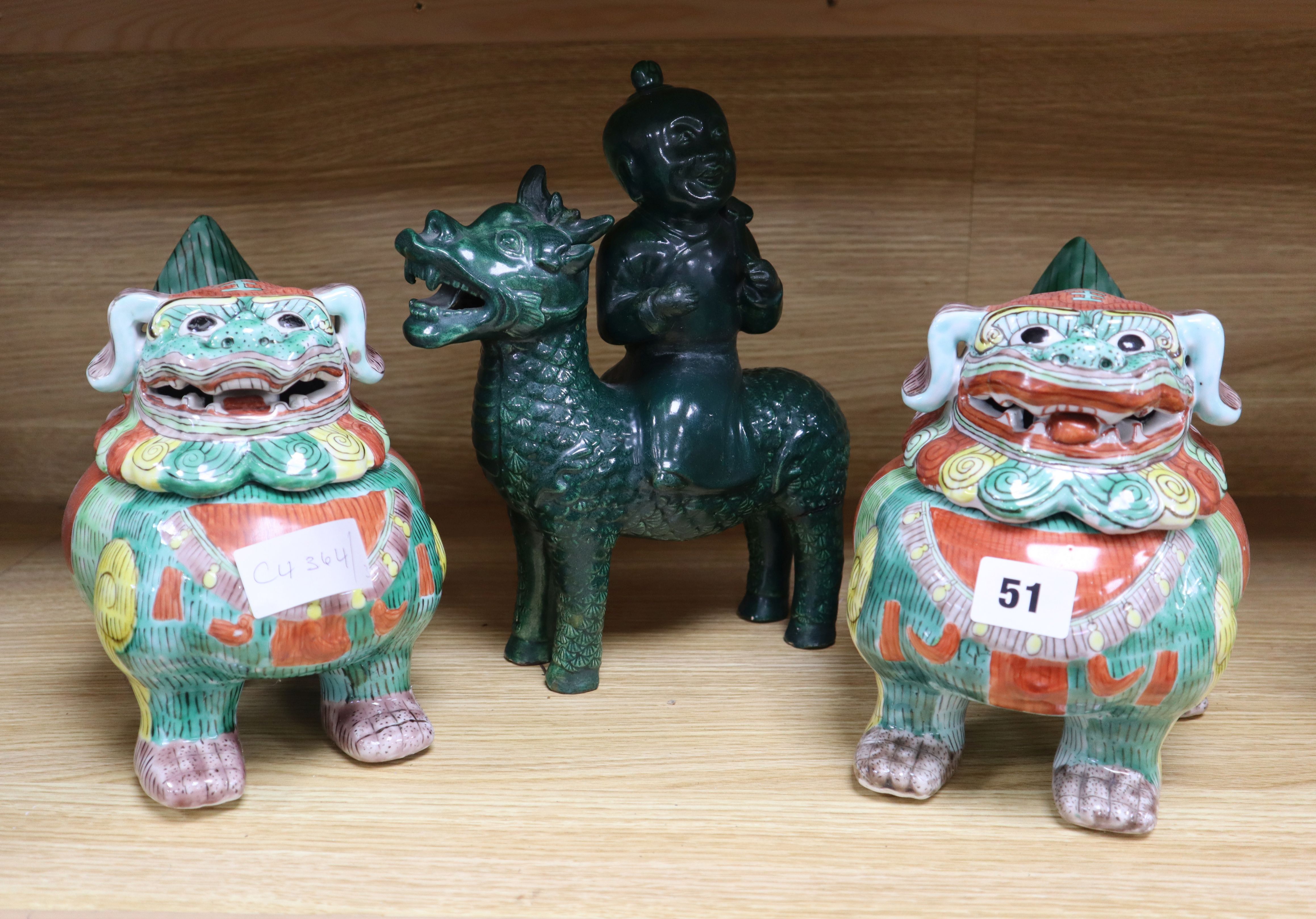 A pair of Chinese lion dog censers and covers and a pottery figure of a boy riding a qilin