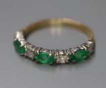 A modern 18ct gold, emerald and diamond seven stone half hoop ring, size K.