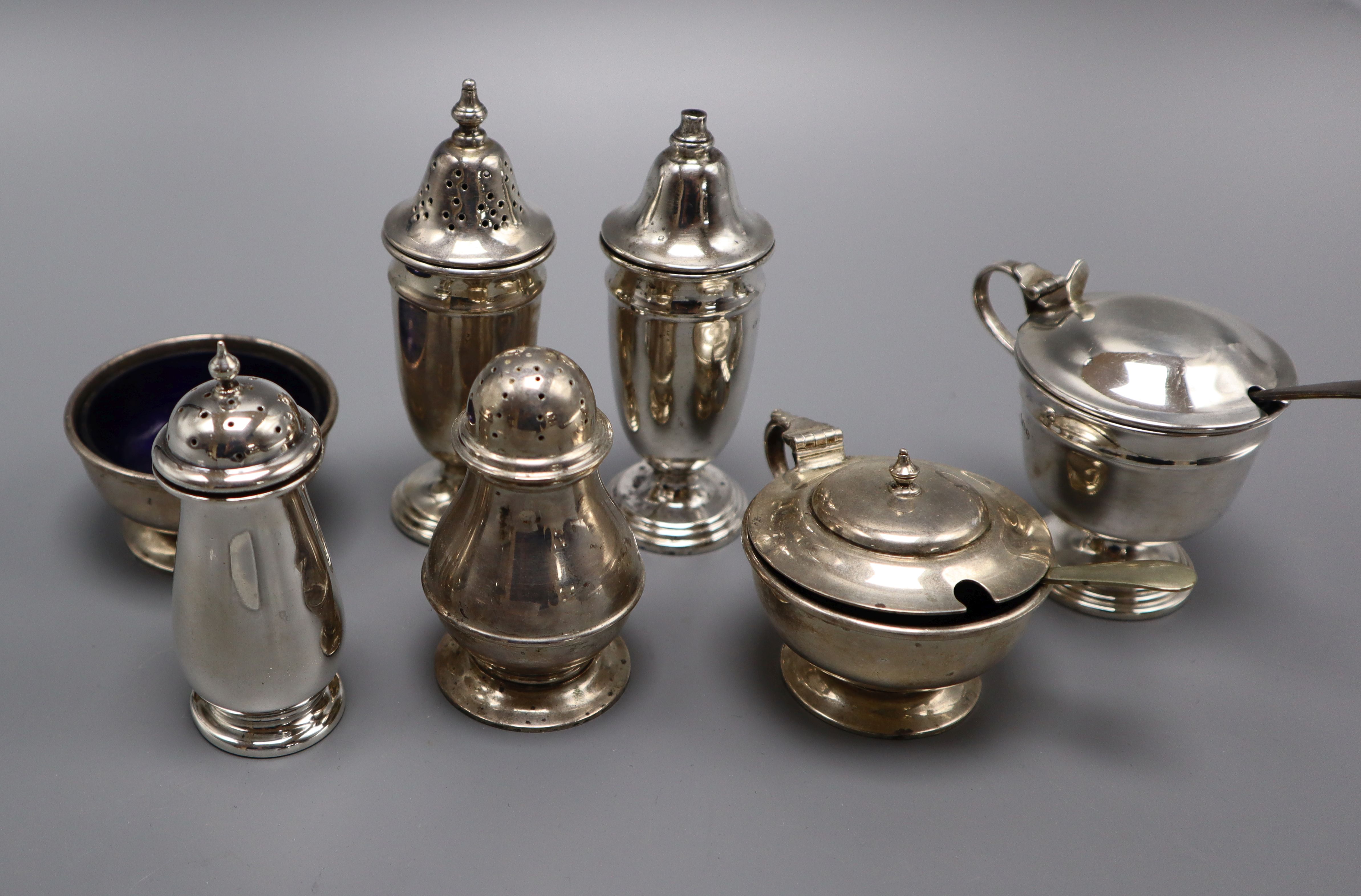 Two mid 20th century silver three piece condiment sets and one other silver pepperette.