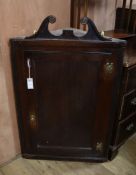 A George III oak hanging corner cupboard W.64cm