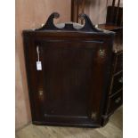 A George III oak hanging corner cupboard W.64cm