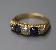 An 18ct, graduated sapphire and diamond set five stone half hoop ring, size L.