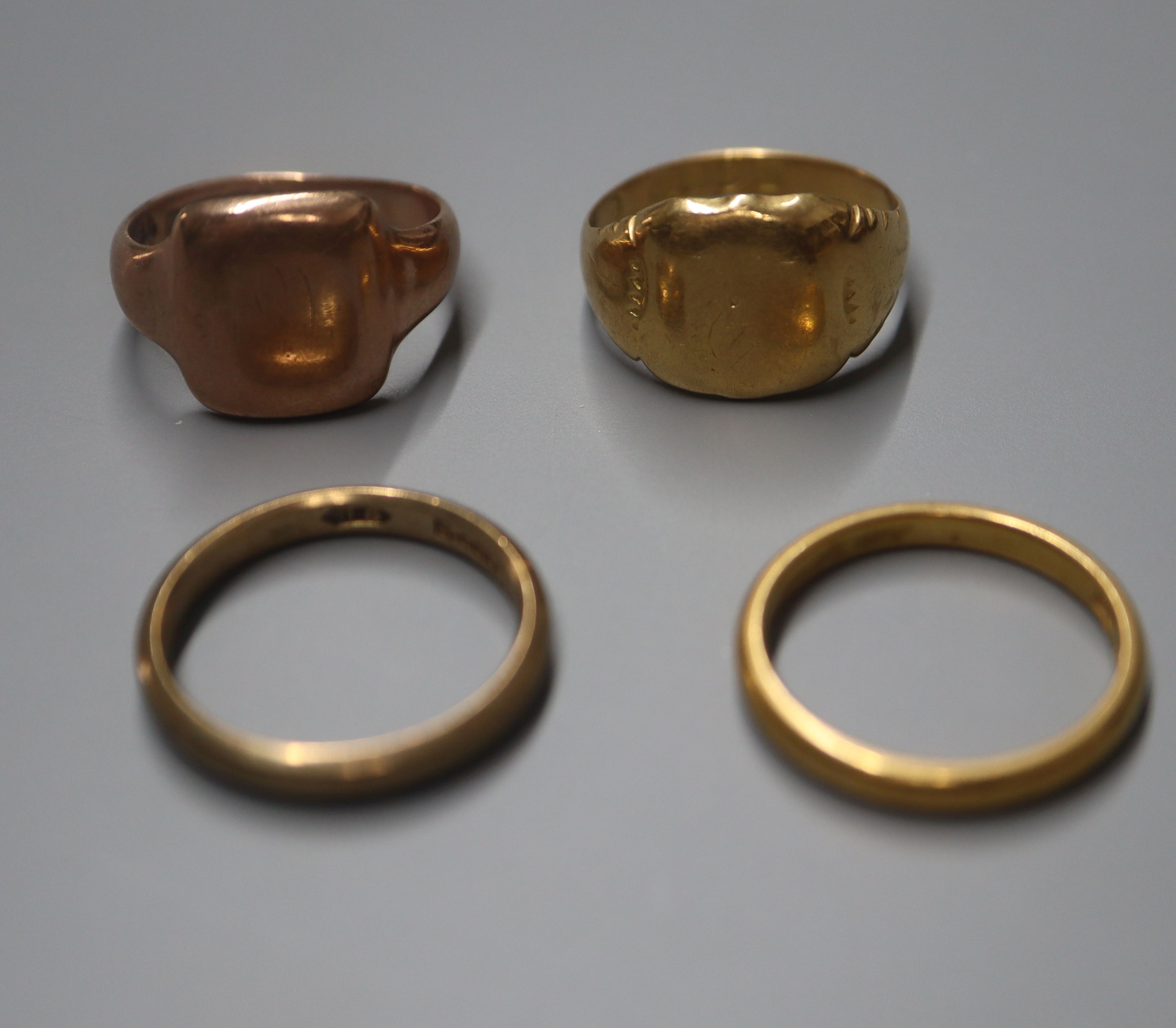 A 22ct. gold wedding band, an 18ct. gold signet ring and two 9ct. gold rings.