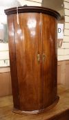 A George III mahogany bowfront hanging corner cabinet W.58cm