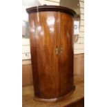 A George III mahogany bowfront hanging corner cabinet W.58cm