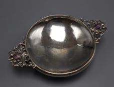 A George V Arts & Crafts silver quaich with cabochon amethyst set pierced handles, John Walker,