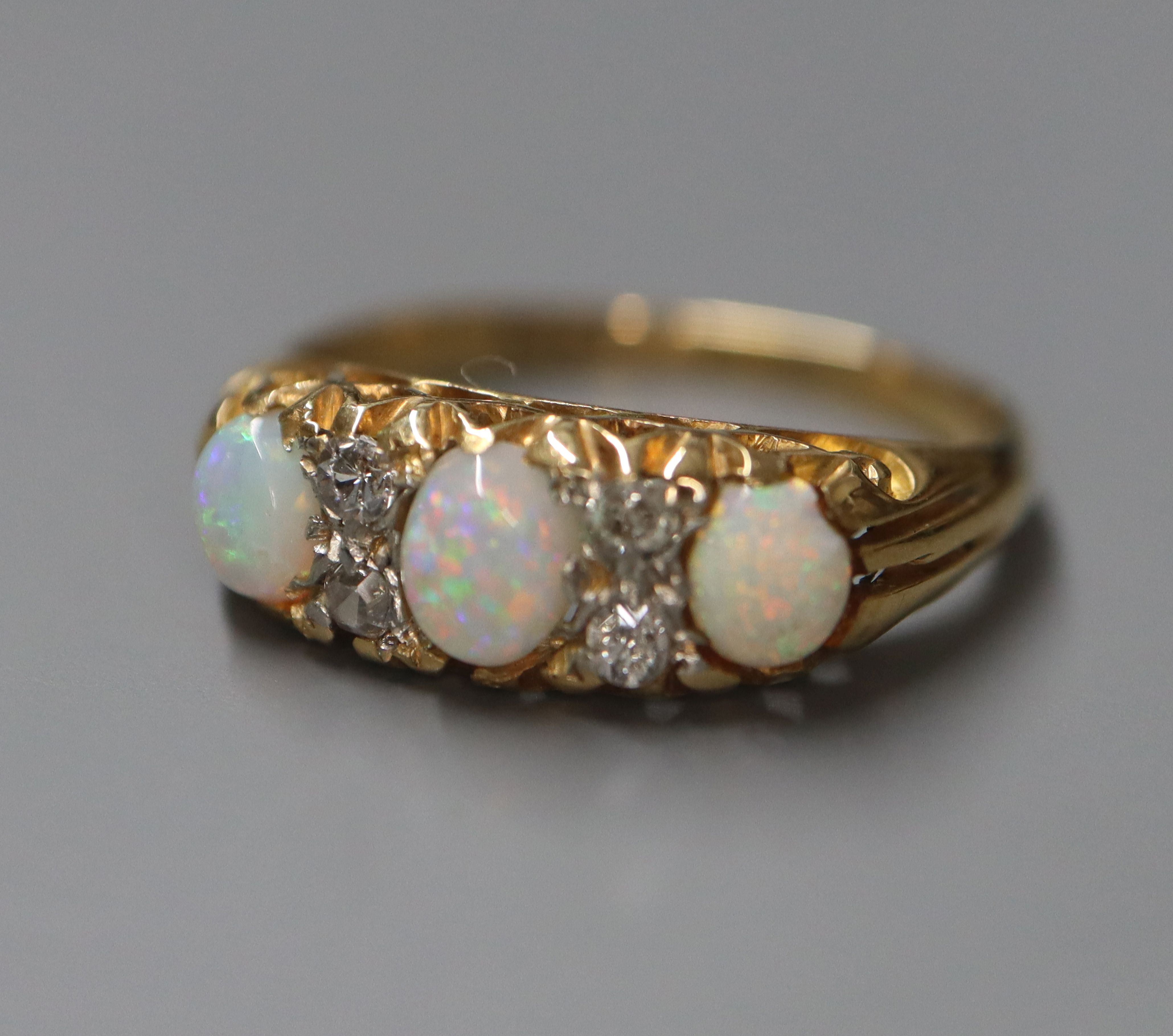 An 18ct and 'plat', white opal and diamond set half hoop ring, size K.