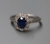 A white metal, sapphire and diamond oval cluster ring, size L.