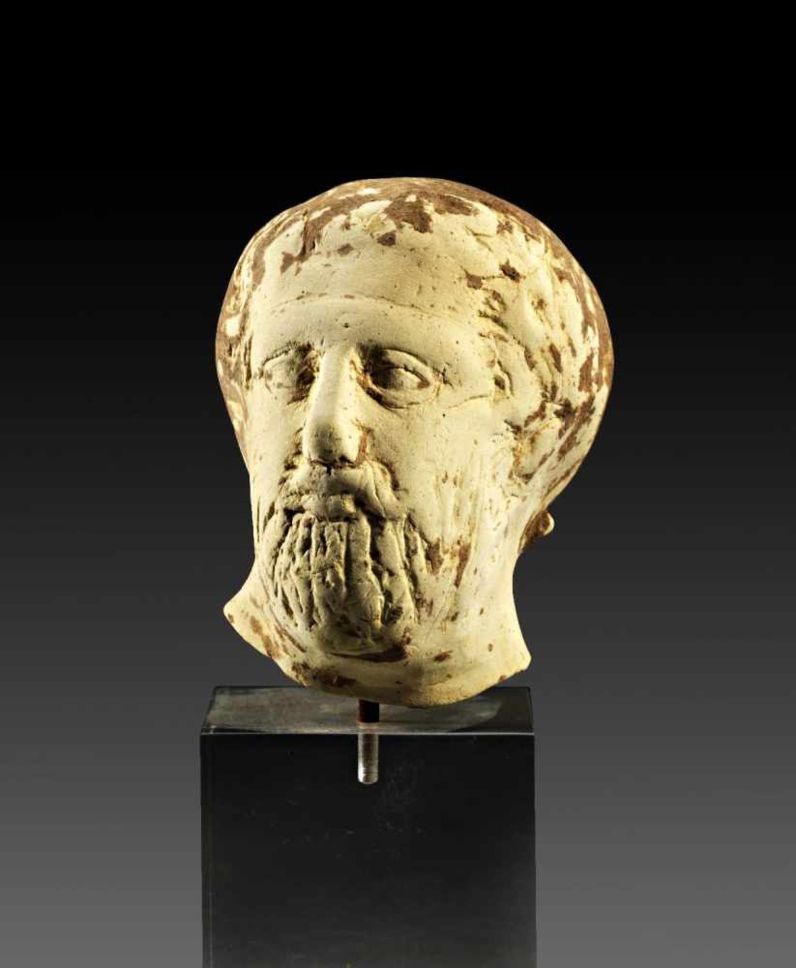 Kopf eines Griechen. Tarent, spätes 5. - 4. Jh. v. Chr. H 6,6cm. Aus hellbeigem Ton. Vollplastischer