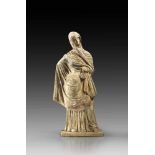 Tanagra figurine with colour traces. Round burning hole on the back. Statuette of a young woman