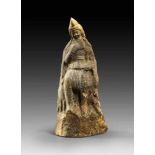 Statuette of Attis with phrygian cap and with syrinx flute, sitting on a rock, to his sides a