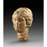 Head of a young woman. 3rd century B.C. Wearing a diadem and earrings. Broken in the neck,